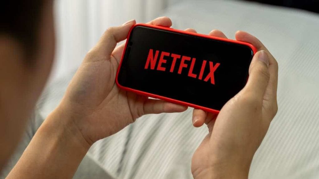 Netflix pledges up to $100 million toward ‘economic opportunity for Black communities’ watching Netflix on a phone